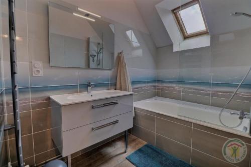 a bathroom with a sink and a tub and a mirror at La ville es brets in Saint-Jouan-des-Guérets