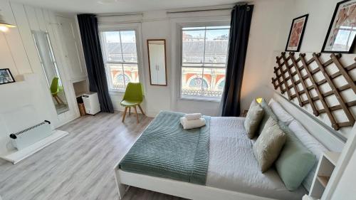 a bedroom with a large bed and two windows at Stylish 2-Bedroom Flat in Barbican Centre near Farringdon with Rooftop Terrace in London