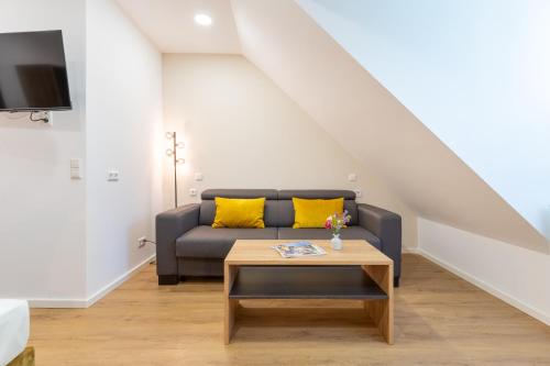 a living room with a couch and a table at Chérisy Hotel Konstanz - Self Check-in Only in Konstanz