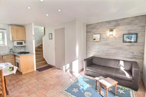 a living room with a leather couch and a kitchen at Houat in Surzur