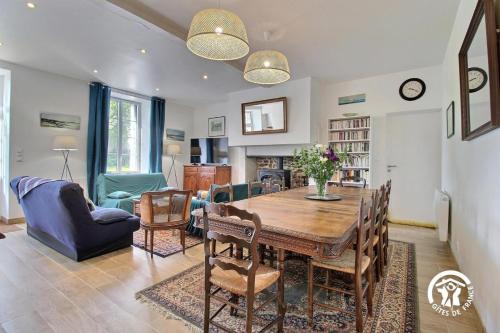 a dining room and living room with a table and chairs at La bretonniere in Taupont