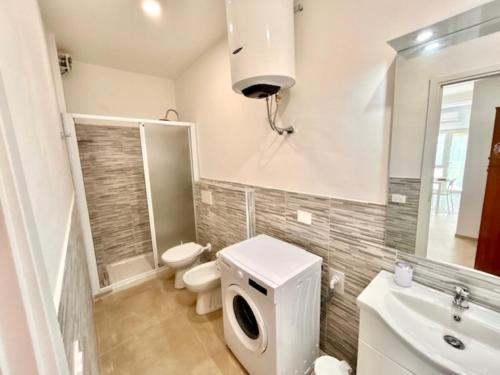 a white bathroom with a toilet and a sink at Mono Limone dx con corte, posto auto ed aria condizionata a due passi dal mare in Marcelli