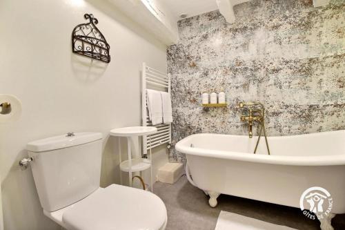 un bagno con una vasca bianca e un water di L'ecorce de bretagne a Langonnet