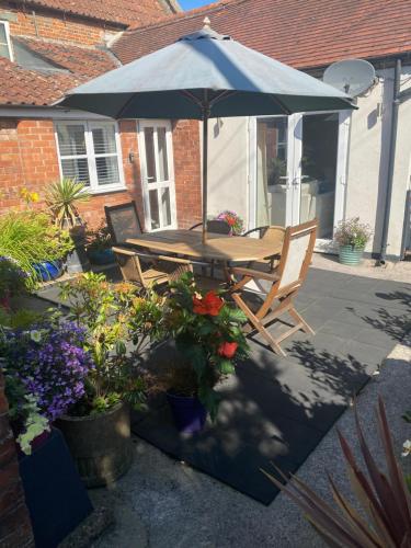 a table and chairs under an umbrella on a patio at The Annexe in Ditcheat in Ditcheat