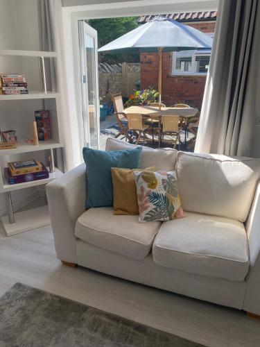 a white couch in a living room with an umbrella at The Annexe in Ditcheat in Ditcheat