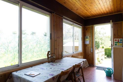 een kamer met een tafel en twee grote ramen bij Casa Nina in Somo