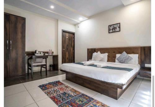 a bedroom with a bed and a desk and a table at Hotel Naman in Udaipur