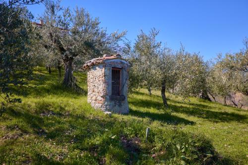 a small stone pillar in a field with trees at Oleum Guest House in Mirabello Sannitico