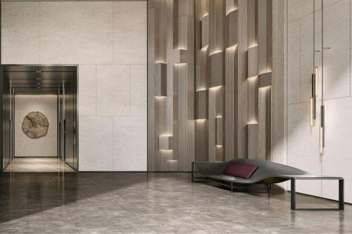 a lobby with a green couch and a elevator at AC Hotel Suzhou Industrial Park in Suzhou