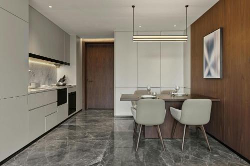 a kitchen with a table and two white chairs at AC Hotel Suzhou Industrial Park in Suzhou