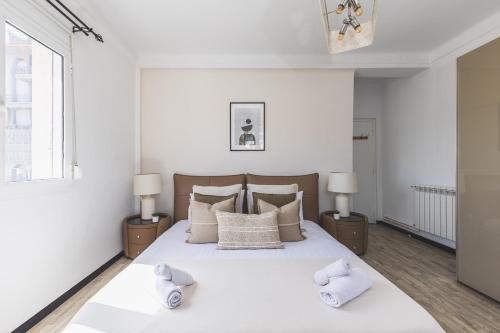 a bedroom with a large white bed with two night stands at Majestueux Appartement 2 pièces à Hydra in Hydra