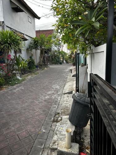 an empty street with a trash can next to a fence at Newly furnished small balinese house quiet area in Perean
