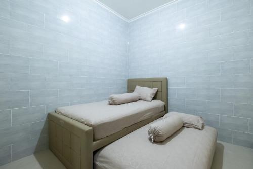 two twin beds in a room with blue tiles at Newly furnished small balinese house quiet area in Perean