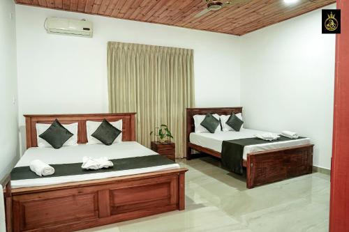 a bedroom with two beds in a room at Ravana Guest House in Nilaveli