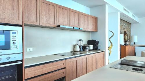 a kitchen with wooden cabinets and a counter top at Anzhu Seamate Villa Samui in Amphoe Koh Samui