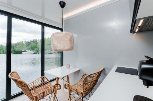 une salle à manger avec une table et des chaises et une grande fenêtre dans l'établissement L'Escale Royale Saint-Fargeau-Ponthierry - Seine - Melun, à Boissise-le-Roi