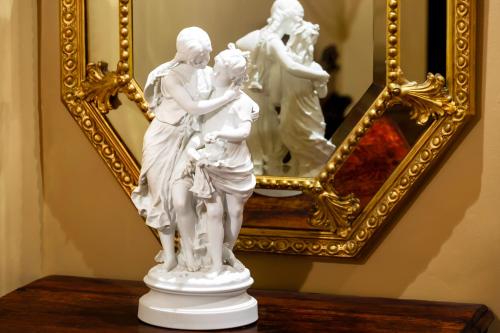 a statue of a woman and a man in front of a mirror at Thorngrove Manor in Stirling