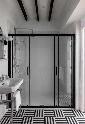 a bathroom with a glass door with a sink at White Hart Hotel in Dorchester on Thames