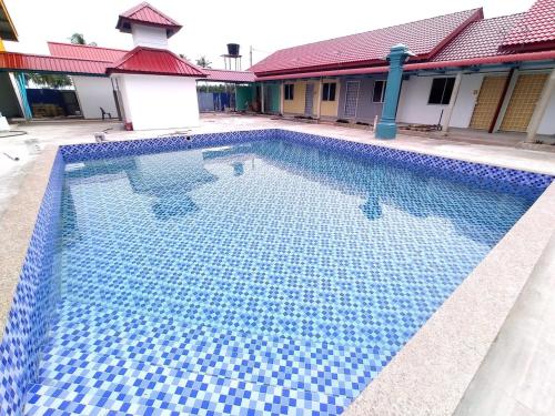 a swimming pool with blue tiles on it at ADA Resort in Kota Bharu