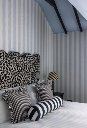 a bedroom with a bed with black and white pillows at White Hart Hotel in Dorchester on Thames