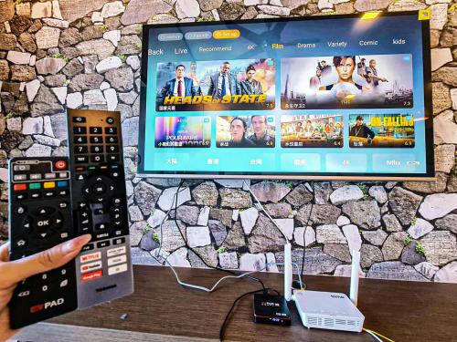 a person holding a remote control in front of a tv at Atlantis Residence Melaka by YouBNB Homestay in Melaka