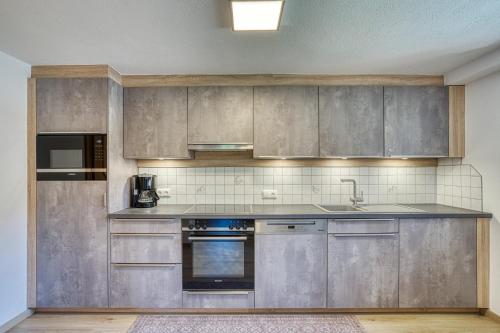 a kitchen with stainless steel cabinets and a sink at Haus St. Bernard in Pettneu am Arlberg