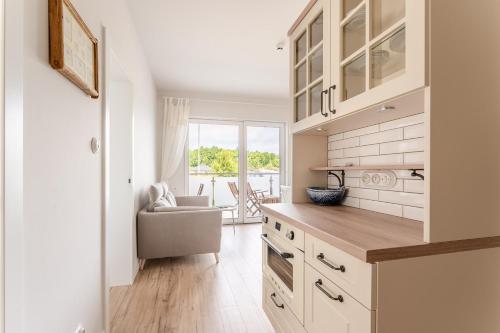 a kitchen with a counter and a chair in a room at Sunset Resort VI, Nadmorska 98A in Grzybowo