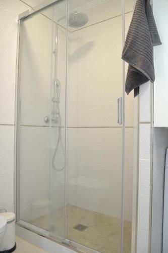 une douche avec une porte en verre dans une salle de bain dans l'établissement Listen the BAY - 230, à Costa del Silencio