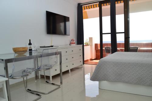 - une chambre avec une table en verre et un lit dans l'établissement Listen the BAY - 230, à Costa del Silencio