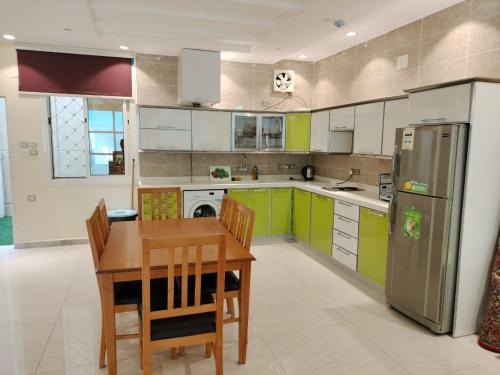 a kitchen with a table and chairs and a refrigerator at فلل الكناري in Taif