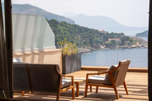 a balcony with chairs and a view of the water at Rixos Premium Dubrovnik in Dubrovnik
