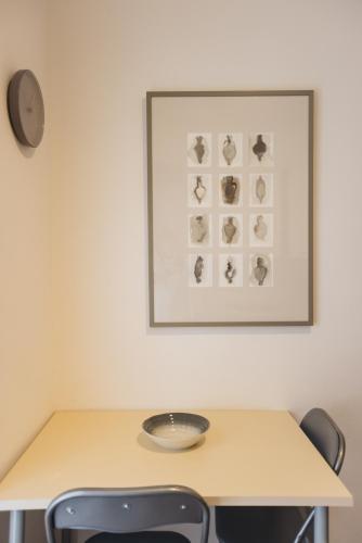 a table with two chairs and a picture on the wall at Appartamento in zona centrale DIMORA FIDUCIA in Pescara