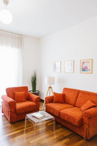 a living room with two orange couches and a table at Appartamento in zona centrale DIMORA FIDUCIA in Pescara
