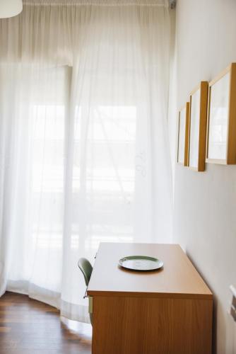 a desk with a plate on it in front of a window at Appartamento in zona centrale DIMORA FIDUCIA in Pescara