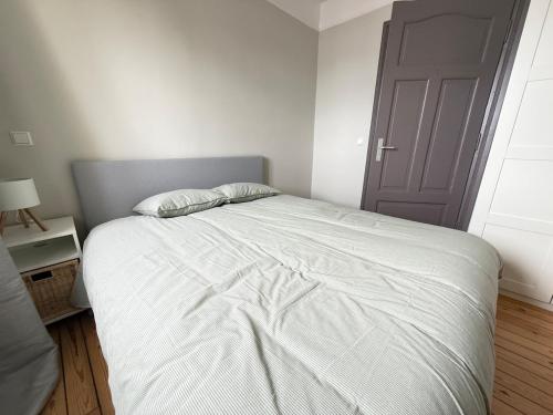 a bedroom with a large white bed with a door at Le Gaston de Belair - Room 005 - 2nd floor - shared Kitchen in Ferme Thibesart