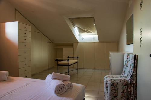a attic bedroom with a bed and a chair at La Casa di Lucia in Marcelli
