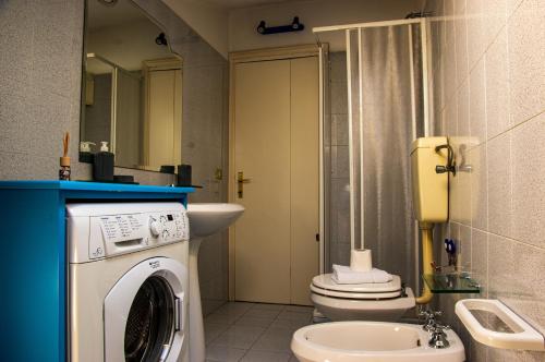 a bathroom with a washing machine and a toilet at La Casa di Lucia in Marcelli