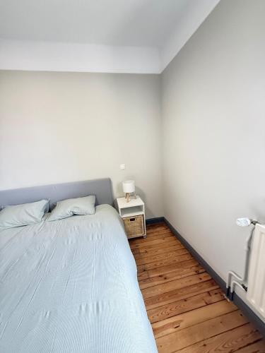 a white bedroom with a bed and a night stand at Le Gaston de Belair - Room 005 - 2nd floor - shared Kitchen in Ferme Thibesart