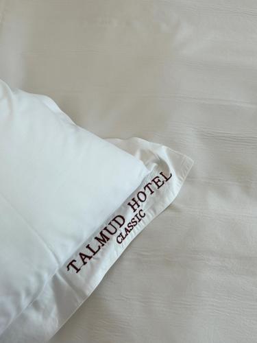 a white pillow with the words hammond hotel on it at Talmud Hotel Classic Taiwan Boulevard in Taichung