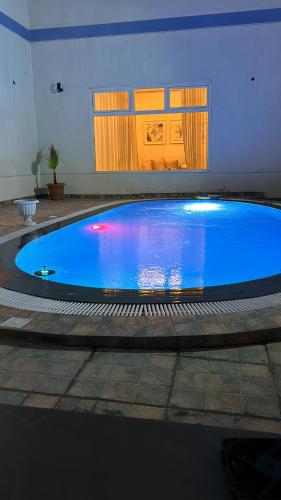 a large blue swimming pool in a building at للسيدات فقط in An Nāmī