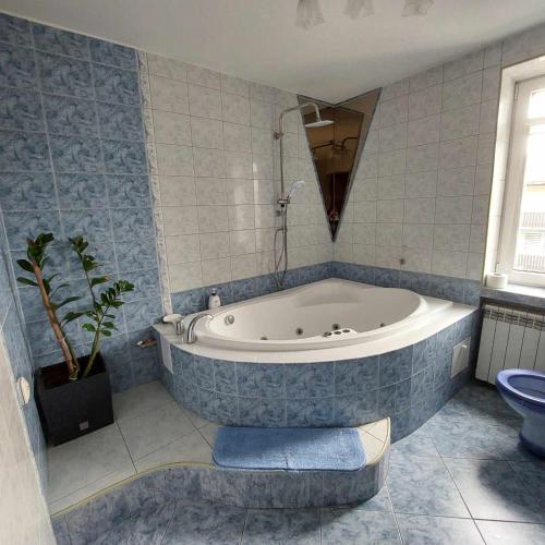 a bathroom with a tub and a toilet and a sink at PENSJONAT KAPRYS in Jesionka