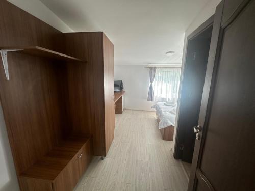 a hallway with a room with a bed and a wooden door at Riz apartamant in Bacău