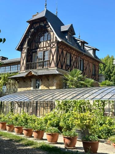 a large building with potted plants in front of it at Château De La Bûcherie in Saint-Cyr-en-Arthies