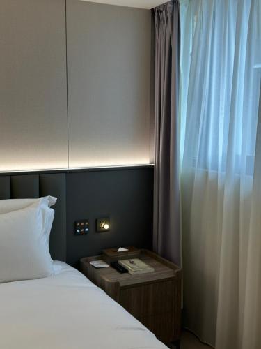 a hotel room with two beds and a window at Talmud Hotel Classic Taiwan Boulevard in Taichung