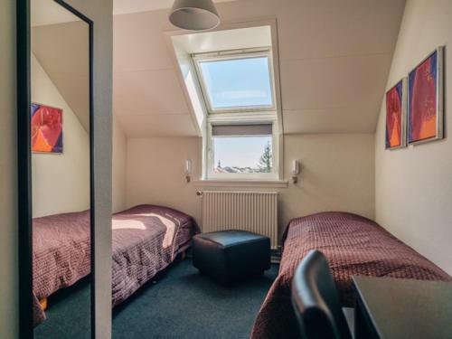 a bedroom with two beds and a window at Støberiet in Svendborg