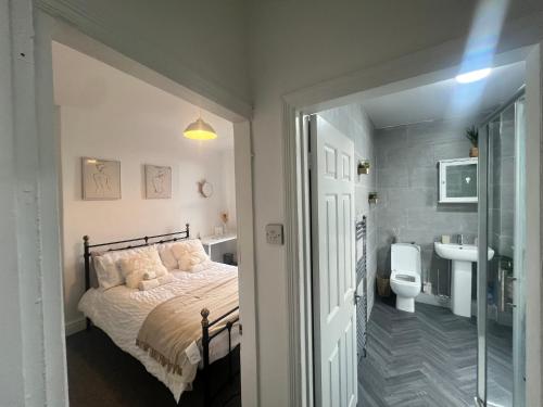 a bedroom with a bed and a sink and a toilet at The bluebird Bed and Breakfast I in Headingley