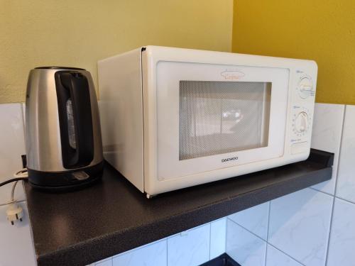 a microwave sitting on top of a kitchen counter at TinyHouse "Comet" am See, an der Mecklenburger Seenplatte in Fürstenberg-Havel