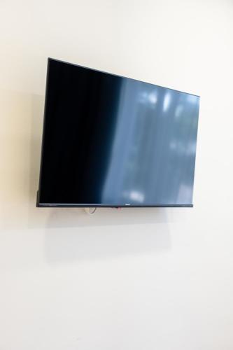 a flat screen tv hanging on a white wall at Chérisy Hotel Konstanz - Self Check-in Only in Konstanz