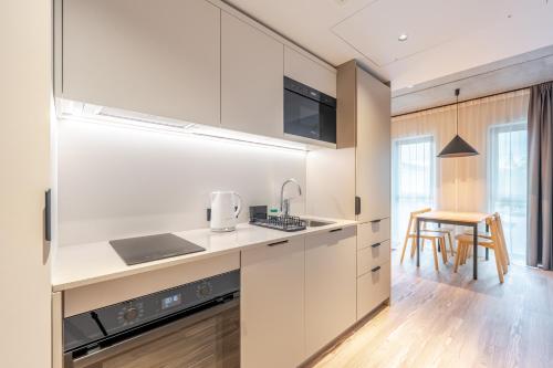 a kitchen with white cabinets and a table at Noli Gdansk Old Town in Gdańsk