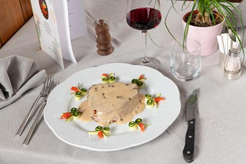 a white plate with a piece of food on a table at Hotel Granta Parey in Rhêmes-Notre-Dame